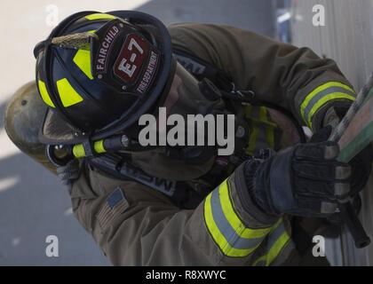 Ein Feuerwehrmann aus dem 92. Tiefbau Squadron Feuerwehr Praktiken eine Flucht Technik bei Fairchild Air Force Base, Washington, März 17, 2017. Us Air Force Feuerwehrmänner spezialisierten Ausbildungseinrichtungen nutzen zu simulieren, die Sie in einem echten Feuer ausgesetzt sein können. Stockfoto