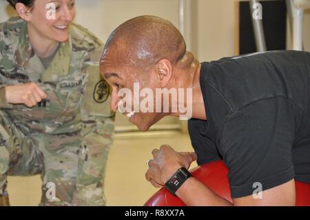 Physiotherapeuten, US-Armee Kapitän Lindsay B. Gordon, Links, beauftragt das Kommando und General Staff College Student, U.S. Army Maj. Calvin "Quake" Peterson auf die korrekten Techniken für die Stärkung der Core mit einem Gymnastikball. Die Executive Wellness Physikalische Therapie Programm personalisiert Programme für Studierende körperliche Stärke und Flexibilität, Munson Armee Health Center, Fort Leavenworth, 1. März 2017 zu verbessern. Stockfoto