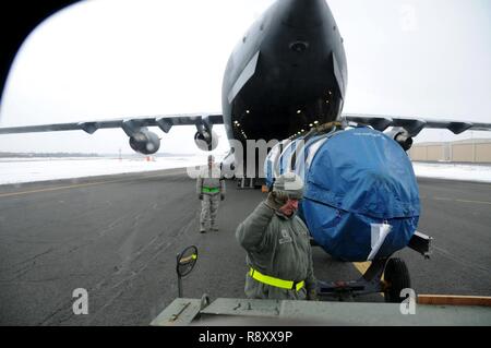 Master Sgt. Brian Charron und Chief Master Sgt. James Burke, links, an der 104 Fighter Wing, Massachusetts Air National Guard, laden Ausrüstung auf einem C-17 Globemaster III, dem 445Th Airlift Wing, Wright Patterson Air Force Base, Ohio zugewiesen. Die C-17 departed Barnes Air National Guard Base, 14. März 2018, im Rahmen einer Theater-Paket zur Unterstützung der Operation Atlantic lösen. Einmal im Theater, die Ladung wird an mehreren Standorten zur Unterstützung von Übungen und Training mit unseren Verbündeten und Partnern. Stockfoto