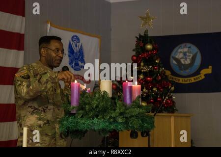 Us-Armee Kaplan (Kapitän) Dilio Onyejiuwa, zum Schwarzen Meer Bereich Support Team zugewiesen ist, leuchtet eine Kerze während einer Weihnachten Zeremonie an Mihail Koglniceanu Airbase, Rumänien, Dez. 6, 2018. Us-amerikanische und kanadische Service Mitglieder verbrachten Mittag feiern gemeinsam Weihnachten Traditionen während ein Weihnachtsbaum Zeremonie. Stockfoto