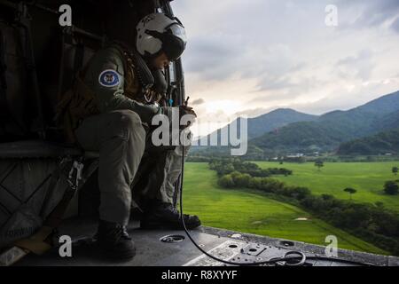 TRUJILLO, Honduras (31. 6, 2018) - Naval Aircrewman (Hubschrauber) 2. Klasse Connor McSpadden, von Charlette, N.C., führt eine Erhebung der honduranischen Luftraum in der Vorbereitung für die vertikale Regalauffüllung aus an Bord einer MH-60S Seahawk, zu der "Ritter" der Hubschrauber Meer Combat Squadron (HSC) 22 zugeordnet. USNS Comfort (T-AH20) ist auf einer 11-Woche medizinische Unterstützung Mission in Zentral- und Südamerika als Teil des US Southern Command's Enduring Promise Initiative. Arbeiten mit Gesundheit und Regierung Partner in Ecuador, Peru, Kolumbien und Honduras, die eingeschifften Medical Team wird ca Stockfoto