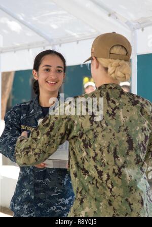 TRUJILLO, Honduras (31. 6, 2018) - Lt. j.g. Karen Jimenez Gudino, von Phoenix, übergibt eine medizinische Versorgung nach unten eine Zeile beim Einrichten einer von zwei medizinische Websites. Das Hospitalschiff USNS Comfort (T-AH20) ist auf einer 11-Woche medizinische Unterstützung Mission in Zentral- und Südamerika als Teil des US Southern Command's Enduring Promise Initiative. Arbeiten mit Gesundheit und Regierung Partner in Ecuador, Peru, Kolumbien und Honduras, die EINGESCHIFFTEN medizinisches Team kümmert sich an Bord und an Land-basierte medizinische Websites, wodurch der Druck auf die nationalen medizinischen Systeme zu entlasten, zum Teil verursacht durch einen Anstieg Stockfoto