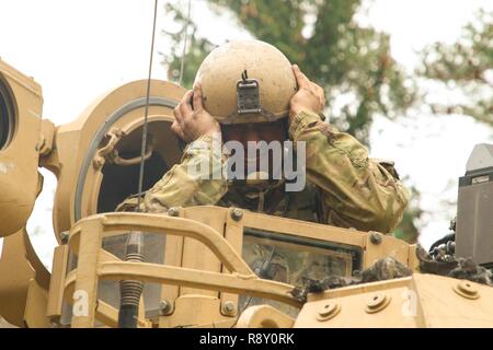 Staff Sgt. Andrew Trevino mit 2Nd Battalion, 5th Cavalry Regiment, 1st Armored Brigade Combat Team, 1.Kavallerie Division, passt seine Kampf Fahrzeug Crewman tanker Helm in der gunner Revolver eines M3 Bradley Fighting Fahrzeug während der Übung kombinierte Lösung XI, Dez. 7, 2018 Hohenfels, Deutschland. CBRXI Übung gibt der US-Army's Regional zugeteilten Kräfte in Europa die Möglichkeit, eine Combat Training Center Rotation mit einer gemeinsamen, multinationalen Umfeld, ihre Integration in die US-Army Europe Operationen auszuführen. Stockfoto