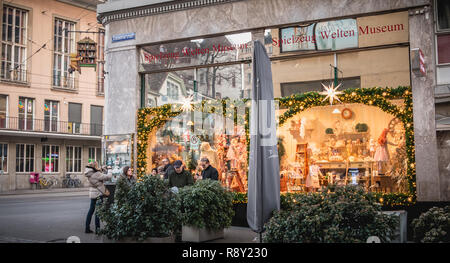 Basel, Schweiz, 25. Dezember 2017: Menschen im Chat vor dem Spielzeugmuseum für Weihnachten mit Girlanden und Kugeln dekoriert Stockfoto