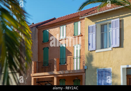 Farben der Provence, Frankreich, Sommer in der kleinen Stadt am Mittelmeer, bunten Fassaden und Fenster und Palmen. Stockfoto