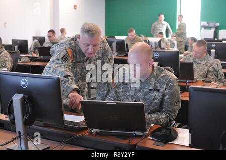 U.S. Army Chief Warrant Officer 4 Mike Laramee (links), Verteidigung Bewegung Koordinator, beauftragt Staff Sgt. Scott Beulen, Bewegung NCO, beide mit Joint Force Headquarters, Vermont Nationalgarde, während der low-density-militärischen berufliche Fachrichtung (MOS) Training im Camp Johnson, Colchester, Vt, 4. März 2017. Die Ausbildung ist ein jährlicher Bedarf für Bewegung Offiziere und bietet Unterricht und einer schriftlichen Prüfung. Stockfoto