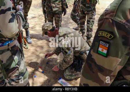 Eine belgische Special Operations Forces Soldat erklärt eine taktische Bewegung Technik zu Niger Armee Soldaten während Flintlock 2017 Diffa, Niger, 28.02.2017. Belgische SOF häufig verwendete Elemente gefunden für die meisten Veranstaltungen den Wert der Einfallsreichtum in einem strengen Umwelt zu stärken. Stockfoto