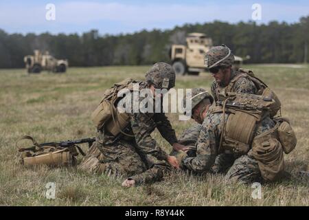 Marines mit Task Force Südwesten neigen zu einem simulierten Unfall während einer taktischen Recovery von Flugzeugen und Personal Training Szenario in Camp Lejeune, N.C., 2. März 2017. Das einwöchige Probe bestand aus beratenden Gesprächen mit afghanischen Rollenspieler, medizinische Schulungen und Kampfszenarien, Vorbereitung des Gerätes für eine bevorstehende Bereitstellung in der Provinz Helmand, Afghanistan. Task Force Südwesten besteht aus etwa 300 Marines, deren Mission werden zu trainieren, beraten und die nationale afghanische Armee 215 Corps 505th Zone der Nationalen Polizei zu unterstützen. Stockfoto