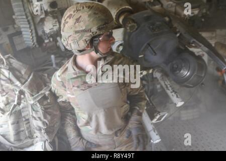 Us-Armee Pfc. Danielle Rubbo, eine Kanone crewmember zu C Akku, 2. Battalion, 82nd Field Artillery Regiment, 3. gepanzerte Brigade Combat Team, 1.Kavallerie Division, Uhren Rauch aus der Verletzung Gießen nach dem Feuern einer artillerie Runde aus einer M109A6 Paladin selbstfahrende Haubitze in der Nähe von Hamam al-Alil, Irak, Jan. 27, 2017. Die Streiks wurden durchgeführt, um den Betrieb der irakischen Sicherheitskräfte zu unterstützen West Mossul von ISIS zu befreien. Eine globale Koalition von mehr als 60 regionalen und internationalen Nationen zusammengefügt hat, damit Partner Kräfte ISIS zu besiegen und Stabilität und Secur wiederherstellen Stockfoto