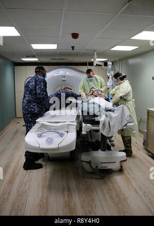 Atlantik (Feb. 22, 2017) Marine und Armee medizinische Fachleute, die Hospital Ship USNS Comfort (T-AH 20) Vorbereitung für die Durchführung einer Computertomographie (CT) auf einem simulierten Unfall während einer Messe Unfallversicherung bohren scannen. Der Komfort unterwegs war Teil des 2017 Comfort Übung (COMFEX). Die Übung ist eine vierteljährliche Schulungen Batterie ausgelegt das medizinische Personal, Support und des öffentlichen Dienstes Seeleute, die an Bord des Schiffes in ihren Pflichten kompetent bedienen zu halten. Komfort bietet ein schwimmendes, mobile, akuten chirurgischen medizinische Einrichtung, wenn man an das US-Militär genannt, und hospit Stockfoto