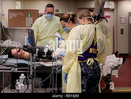 Atlantischer Ozean (22. Februar 2017) - - USA Marine medizinische Fachleute, angeschlossen an das Krankenhaus ship USNS Comfort (T-AH 20), Vorbereiten einer Notoperation auf einem simulierten Gefecht casulty während einer Messe Unfallversicherung bohren durchzuführen, 24.02.22. Die Masse Unfallversicherung bohren war Teil des Schiffes Komfort Übung (COMFEX). Stockfoto