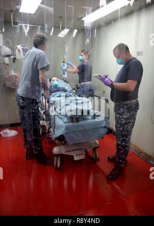 Atlantischer Ozean (22. Februar 2017) - - USA Marine Fachleute, angeschlossen an das Krankenhaus ship USNS Comfort (T-AH 20), für die medizinische Behandlung für eine simulierte ansteckende Krankheit Opfer während einer Messe Unfallversicherung bohren, 24.02.22. Die Masse Unfallversicherung bohren war Teil des Schiffes Komfort Übung (COMFEX). Stockfoto