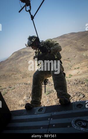 Eine pararescueman von der 82nd Expeditionary Rescue Squadron bereitet aus ein HH-60 Pavehawk bei einem März 2, 2017 rappel, um Lager Lemonnier, Djibouti. Die ausbildung Flug erlaubt pararescuemen, ihre Verfahren zu üben und mögliche zukünftige Ausbildung Standorte Umfrage in der Umgebung. Der 82nd ERQS sind Teil der 449th Air Expeditionary Gruppe Personal Task Force "Einziehung", wo Sie kontinuierliche Personal recovery Tätigkeiten ausüben, damit die regionalen Akteure gewalttätigen extremistischen Organisationen in Ostafrika und auf der Arabischen Halbinsel zu neutralisieren, um zu pr Stockfoto