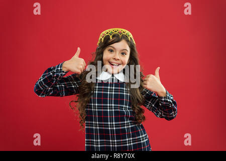 Drehen Sie den Kopf. Kid tragen goldene Krone Symbol der Prinzessin. Kindheit Konzept. Mädchen Cute Baby tragen Krone während rote Hintergrund abheben. Lady little Princess. Jedes Mädchen träumt Prinzessin zu werden. Stockfoto