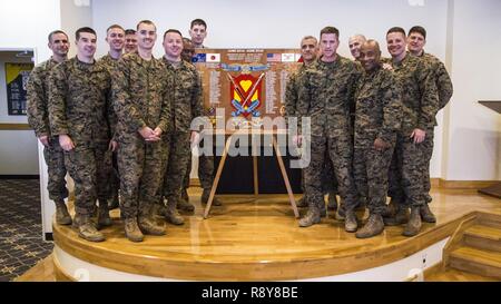 Us-Marines, die mit der 4. Marine Regiment, 3d Marine Division serviert, für ein Foto neben ihrem Plakette als "Shanghai Marine Alumni" von Juni 2014 - Juni 2016 auf Lager Schwab, Okinawa, Japan, 9. März 2017 dar. Us-Marines, Matrosen, und Zivilisten in einer Zeremonie nahm auf 103 Jahre Leistungen vom 4. Marine Regiment als die "älteste" und der "stolzesten" Regiment in den Korps zu reflektieren. Stockfoto