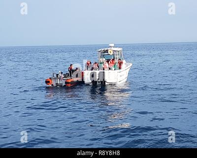 Die Besatzungsmitglieder von der Coast Guard Cutter Tarpon, in St. Petersburg, Florida, entwässern ein 33-Fuß-Boot 23 Meilen westlich von New Port Richie, Florida, Mittwoch, 3. März 2017 homeported. Die Küstenwache erhielt eine mayday Anruf von drei Personen an Bord der Yacht nach begann es Überschwemmungen 100 Meilen vor der Küste. Stockfoto