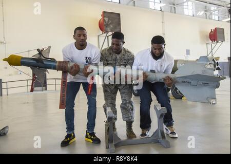 Malcolm Mitchell, Links, Breite New England Patriots' Empfänger und Super Bowl LI Meister, Kapitän Eric Johnson 23 d Bauingenieur Squadron Commander und James Rom, ehemaliger NFL festes Ende Anheben eines Ziel 9 Sidewinder II-Rakete während Mitchell's Besuch März 7, 2017, bei Moody Air Force Base, Ga. Mitchell, der ein Valdosta native, erhielten einen Einblick in einen typischen Tag im Leben einiger der Moody's Flieger aus der 23d Fighter Group, 23 d-Gruppe 23d Mission Support Group, und der 820Th Base Defense Group. Bei seinem Besuch, Mitchell verbrachte auch Zeit mit Flieger und Autogramme für Lokalpatrioten f Stockfoto
