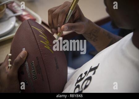 Malcolm Mitchell, rechts, breite New England Patriots' Empfänger und Super Bowl LI Meister, Zeichen ein Fußball bei einem Besuch März 7, 2017, bei Moody Air Force Base, Ga. Mitchell, der ein Valdosta native, erhielten einen Einblick in einen typischen Tag im Leben einiger der Moody's Flieger aus der 23d Fighter Group, 23 d-Gruppe 23d Mission Support Group, und der 820Th Base Defense Group. Bei seinem Besuch, Mitchell verbringt die Zeit mit den Fans den lokalen Patrioten". Stockfoto