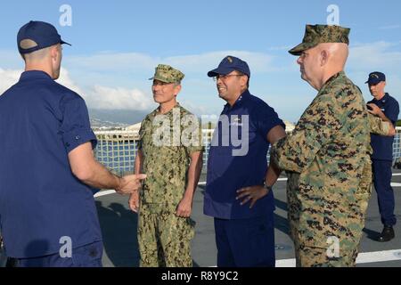 Leutnant Patrick Frost, ein Combat Systems Offizier an Bord der U.S. Coast Guard Cutter Munro (WMSL 755), Schriftsatz Adm. Harry Harris, Jr., Commander, US Pacific Command, hintere Adm. Vincent Atkins, Commander, Coast Guard 14. Bezirk und Generalleutnant David Berger, Commander, U.S. Marine Corps Forces, Pazifik, über Schiff Systeme in Honolulu, 8. März 2017. Munro ist das sechste von neun geplanten National Security Cutter und den vierten Platz in der an der Westküste in Alameda, Kalifornien homeported werden Stockfoto