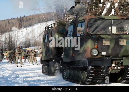 Soldaten skijour hinter einer kleinen Einheit Unterstützung Fahrzeug als Teil der US-Armee Alaska Winter Spiele am Fort Wainwright, Alaska, 9. März 2017. Veranstaltungen in diesem Jahr gehören Downhill Ski Racing, live-fire biathlon Range, Stress schießen, land Navigation, Skijöring, Einrichten der Arktis 10-Mann Zelt und Herd richtig, und die Bewertung und Behandlung von einem Unfall in der extremen Kälte. Als Amerika's Arctic Krieger und Experten der US-Armee in Überlebenden, Betrieb, kämpfen und gewinnen in extrem kalten Wetter und Höhenlage Umgebungen, alle Fertigkeiten, die während der Spiele getestet sind kritisch für alle USARAK S Stockfoto