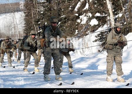 Soldaten skijour hinter einer kleinen Einheit Unterstützung Fahrzeug als Teil der US-Armee Alaska Winter Spiele am Fort Wainwright, Alaska, 9. März 2017. Veranstaltungen in diesem Jahr gehören Downhill Ski Racing, live-fire biathlon Range, Stress schießen, land Navigation, Skijöring, Einrichten der Arktis 10-Mann Zelt und Herd richtig, und die Bewertung und Behandlung von einem Unfall in der extremen Kälte. Als Amerika's Arctic Krieger und Experten der US-Armee in Überlebenden, Betrieb, kämpfen und gewinnen in extrem kalten Wetter und Höhenlage Umgebungen, alle Fertigkeiten, die während der Spiele getestet sind kritisch für alle USARAK S Stockfoto