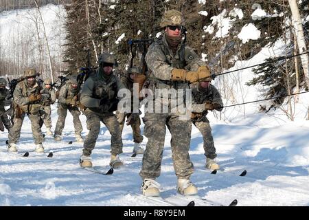 Soldaten skijour hinter einer kleinen Einheit Unterstützung Fahrzeug als Teil der US-Armee Alaska Winter Spiele am Fort Wainwright, Alaska, 9. März 2017. Veranstaltungen in diesem Jahr gehören Downhill Ski Racing, live-fire biathlon Range, Stress schießen, land Navigation, Skijöring, Einrichten der Arktis 10-Mann Zelt und Herd richtig, und die Bewertung und Behandlung von einem Unfall in der extremen Kälte. Als Amerika's Arctic Krieger und Experten der US-Armee in Überlebenden, Betrieb, kämpfen und gewinnen in extrem kalten Wetter und Höhenlage Umgebungen, alle Fertigkeiten, die während der Spiele getestet sind kritisch für alle USARAK S Stockfoto