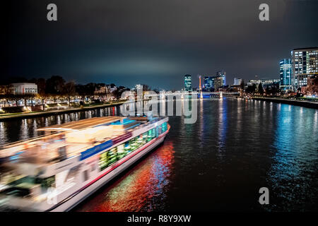 Frankfurt am Main bei Nacht mit Schiff im Vordergrund. Stockfoto