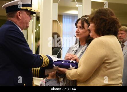 Coast Guard Kapitän Brendan McPherson, Stabschef, Coast Guard 13. Bezirk, präsentiert eine Flagge zur Familie der Kapitän Winslow Buxton (Ret.) während einer Trauerfeier in Buxton ist mit der Ehre, in Bellevue, Washington, 11. März 2017 statt. Buxton zurückgezogen von der Küstenwache nach Umhüllung für 29 Jahre. Us-Küstenwache Stockfoto