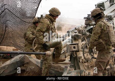 Sgt. Johnnie Morton, runde Läufer für die gun Crew der 1. Abschnitt 1 Platoon, Cobra, Batterie, Field Artillery Squadron, 2d-Cavalry Regiment, US Army, lädt einen 155mm Artillerie Runde auf ein M777A2 Howitzer bei einem Brand Mission vom 8. März 2017 in Grafenwöhr Training Area, Deutschland. Das Geschwader nahmen an Dynamic Front II März 6-9, 2017. Die Übung aktiviert, den USA, Deutschland und der Tschechischen Republik gemeinsam ihre Artillerie Fähigkeiten zu synchronisieren. Stockfoto