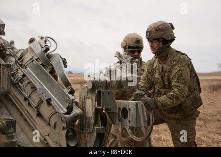 Sgt. David Beale (vorne), Assistant gunner und SPC. Vincent Ventarola, beide Mitglieder der gun Crew für 1. Abschnitt 1 Platoon, Cobra, Batterie, Field Artillery Squadron, 2d-Cavalry Regiment, US Army, leiten Sie einen Brand Mission mit Ihrer M777 A2 Howitzer während einer März 8, 2017 in Grafenwöhr Training Area, Deutschland. Das Geschwader nahmen an Dynamic Front II März 6-9, 2017. Die Übung aktiviert, den USA, Deutschland und der Tschechischen Republik ihre Artillerie Fähigkeiten zu synchronisieren. Stockfoto