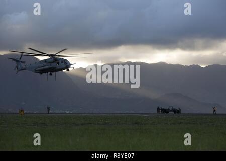 MARINE CORPS BASE HAWAII - Landung Support Specialist mit Transport Services Unternehmen, die Bekämpfung der Logistik Bataillon 3, führt ein CH-53E Super Stallion Hubschrauber Marine schweren Helikopter Squadron 463 zugewiesen, der den Spitznamen "Pegasus", während der externe Heben Ausbildung bei Landing Zone West Feld an Bord der Marine Corps Air Station Kaneohe Bay, 8. März 2017. Dieses Training verbessert die Sprachkenntnisse für die Piloten, wenn umzugsmaterial während Marines auf dem Boden sich sicher zu Dual und Single Lastenaufzüge vorbereiten. Stockfoto