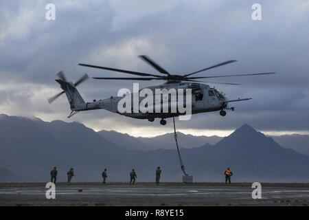 MARINE CORPS BASE HAWAII - Marines mit Transport Services Unternehmen, die Bekämpfung der Logistik Bataillon 3, und Marine schweren Helikopter Squadron 463 externe heben Ausbildung bei Landing Zone West Feld an Bord der Marine Corps Air Station Kaneohe Bay, 8. März 2017. Dieses Training verbessert die Sprachkenntnisse für die Piloten, wenn umzugsmaterial während Marines auf dem Boden sich sicher zu Dual und Single Lastenaufzüge vorbereiten. Stockfoto