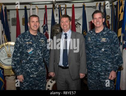 YOKOSUKA, Japan (13. März 2017) hinten Adm. Charles Williams, Commander, Task Force 70, links, Paul Madden, britischer Botschafter in Japan, Mitte, und Kapitän Buzz Donnelly, kommandierender Offizier der Marine nur Vorwärts - bereitgestellt Flugzeugträger USS Ronald Reagan (CVN 76), für ein Foto auf die zeremoniellen Quarterdeck während einer Schiffstour darstellen. Ronald Reagan, das Flaggschiff der Carrier Strike Group 5, bietet eine Bekämpfung bereit, Kraft, schützt und verteidigt die kollektive maritime Interessen seiner Verbündeten und Partnern in der Indo-Asia-Pazifik-Region. Stockfoto