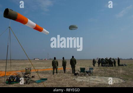 Bulgarische Special Operations Drop Zone Personal sehen Sie sich eine Bulgarische service Mitglied steigen während der Übung thrakischen Frühjahr 17 bei regionalen Flughafen Plovdiv, Bulgarien, 15. März 2017. Fallschirmjäger verlassen die C-130J Super Hercules von rund 1.250 Meter vor dem Abstieg in die Drop Zone. Mehr als 60 US Air Force Piloten von Air Base Ramstein, Deutschland, in kombinierten Flugbetrieb beteiligte sich mit bulgarischen militärischen Beziehungen zu stärken und gemeinsame militärische Fähigkeiten ihrer Nationen Gebäude. Stockfoto