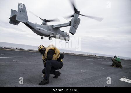 EAST CHINA SEA (16. März 2017) der Luftfahrt Bootsmann Mate (Handling) 3. Klasse Jesse Harris, von Yelm, Washington, zugeordnet zu den Amphibious Assault ship USS BONHOMME RICHARD (LHD 6), geschweifte Klammern auf den Rotor Waschen eines B MV-22 Osprey, der "Flying Tigers" der Marine Medium Tiltrotor Squadron (VMM) 262 zugewiesen wird, wie es von der Flight Deck nimmt während einer Air Assault Übung in der Unterstützung von Amphibischen integration Training (AIT). AIT ist so ausgelegt, dass alle Elemente der Bonhomme Richard Expeditionary Strike Group (BHR ESG) und 31 Marine Expeditionary Unit (MEU) ihre Fähigkeit zu pla zu testen, um zu integrieren. Stockfoto