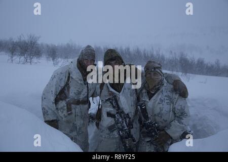 Us-Marines Cpl. Conway Hughes, Links, Kpl. Mason Siegel, Mitte, und Lance Cpl. Charles Pastete, rechts, Vorbereiten während einer Blizzard März 11, 2017 Watch zu stehen, innerhalb des Polarkreises von Norwegen. Marine Drehkraft Europa 17,1 (MRF-E) teilgenommen, die in der Übung gemeinsame Viking. Keine Nation kann sich den heutigen Herausforderungen allein, eines Grundsatzes, der durch die USA, Großbritannien, norwegischen und niederländischen Truppen, die an der Übung teilgenommen haben. Hughes, Siegel und Pastete sind Gewehrschützen mit 1 Platoon, MRF-E. Stockfoto
