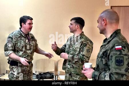 Maj. Jon Anderson (Mitte), Operations Officer, 3. gepanzerte Brigade Combat Team, 4 Infanterie Division, spricht mit der britischen Royal Navy Leutnant Cdr. William Inglis (links), ein NATO-Integration Polen Planer, und Polnischen Oberstleutnant Artur Bogowicz, NFIU Polen Commander, während eines Besuchs durch NFIU Polen Führer, dem Hauptsitz der Brigade an Zagan, Polen, 15. März 2017. Als die aktuelle Drehzahl land Kraft für die U.S. Army Europe Atlantic lösen, 3/4 ABCT's Treffen mit dem NFIU konzentrierte sich auf die Integration von Training Strategie der Feuerwehr mit insgesamt Alliance Ziele. Die kleine NFIU Hauptsitz Stockfoto