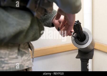 Air Force Staff Sgt. Nicholas Woolridge, ein streifenpolizist mit der 673 d Security Forces Squadron löscht seine Waffe in der 773Rd Bauingenieur Squadron, vor Beginn einer aktiven shooter Inhaftierung übung, März 13. Die Sicherheitskräfte Geschwader auf gemeinsamer Basis Elmendorf-Richardson führt regelmäßig keine - Bekanntmachung der Tests der aktiven shooter Mentalitäten Büros' um. Stockfoto