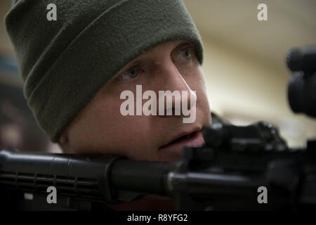 Air Force Staff Sgt. Nicholas Woolridge, ein streifenpolizist mit der 673 d Security Forces Squadron Uhren der Flur als seine Mitarbeiter löscht den nächsten Raum in der 773Rd Bauingenieur Squadron, März 13. Die Sicherheitskräfte Geschwader auf gemeinsamer Basis Elmendorf-Richardson führt regelmäßig keine - Bekanntmachung der Tests der aktiven shooter Mentalitäten Büros' um. Stockfoto