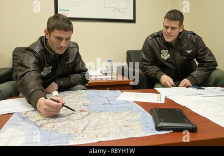 Kapitän Brett Boudreaux, Links und Kapitän Scott Robinson, sowohl zur 22 Airlift Squadron zugewiesen ist, klicken Sie auf den Flugplan für die Sendung der Tag von OSAN FLUGHAFEN, Südkorea, Yokota Air Base, Japan, 9. März 2017. Die Piloten wurden auf einer pazifischen Kanal mission Flying Cargo von Osan Flughafen ab zu Travis Air Force Base, Kalifornien. Stockfoto