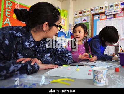 YOKOSUKA, Japan (16. März 2017) - der bootsmann Mate 3. Klasse Erin Marquez, von Pueblo West, Colorado, USA 7 Flotte Flaggschiff USS Blue Ridge (LCC 19), hilft ein Student mit einem Mathe Übung in Sullivan's Grundschule während eines gemeinschaftlichen Beziehungen. Blue Ridge ist in eine umfassende Wartung, um das Schiff weiterhin als eine robuste Kommunikation Plattform in den USA 7 Flotte Einsatzgebiet zu dienen zu modernisieren. Stockfoto