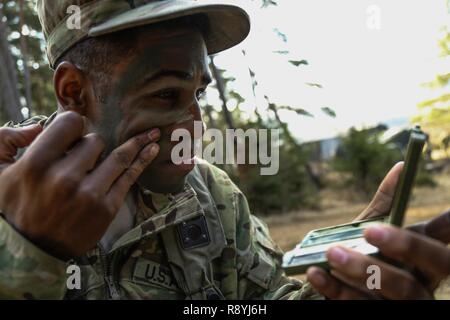 Us-SPC. Marcellus Golliday der Zentrale und Sitz der Gesellschaft, 1.BATAILLON, 503Rd Infanterie Regiment, 173Rd Airborne Brigade gilt Camouflage in Vorbereitung für einen simulierten Angriff während der Übung Allied Geist VI im 7. Armee den Befehl Hohenfels Training Area, Deutschland, Jan. 16, 2017. Übung Allied Geist VI umfasst über 2.770 Teilnehmer aus 12 NATO und Partner für den Frieden der Nationen, und Übungen taktische Interoperabilität und Tests sichere Kommunikation innerhalb der Allianz Mitglieder und Partner Nationen. Stockfoto