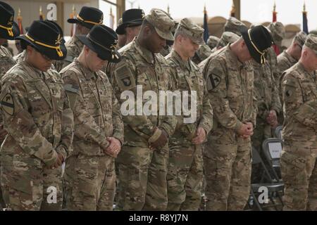 (Von links nach rechts) den Befehl Sgt. Maj. Jill Crosby, Senior Soldaten Advisor der 1 Kavallerie Division Sustainment Brigade, Oberst Christopher Colavita, Kommandant der 1. Cav. Div. Sustainment Brigade; Command Sgt. Maj. Perry Williamson, Senior Advisor Soldaten des 401St Army Field Support Brigade, Oberst Aaron Stanek, Kommandant der 401St AFSB; und 1. Kavallerie Division kommandierenden General Generalmajor John Thomson Bogen ihre Köpfe im Gebet während der anrufung der bei der Übertragung der Autorität Zeremonie am Lager Buehring, Kuwait, den 12. März. Nach neun Monaten erreichte der 3. Gepanzerten Brigade Combat Team, 1 Ar Stockfoto