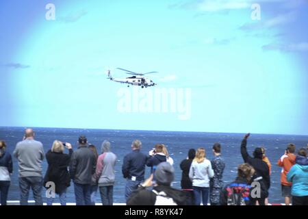 Atlantischer Ozean (19. März 2017) - die Freunde und Familien Crewmitglieder 'watch aus dem Flight Deck der Amphibisches Schiff USS Iwo Jima (LHD7) als SH-60 Seahawk führt einen Vorbeiflug bei Freunden und Familie Tag der Kreuzfahrt. Iwo Jima Matrosen hosted 852 Freunde und Familie Mitglieder während der Kreuzfahrt, die als eine Gelegenheit, das Leben unterwegs an Bord ein Schiff der Marine zu erleben. Stockfoto