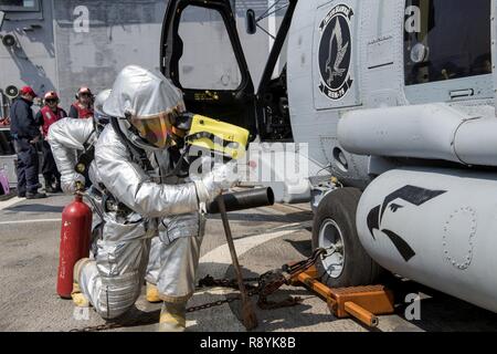 Koreastraße (19. März 2017) Maschinen Handwerker Feuerwehrmann Joihn Suarez, aus Miami, mit einer Wärmebildkamera auf dem Flugdeck der Ticonderoga-Klasse geführte-missile Cruiser USS Lake Champlain (CG57) bei einem Crash und Bergung bohren. Lake Champlain ist in regelmäßigen Western Pacific Bereitstellung mit der Carl Vinson Carrier Strike Group als Teil der US-Pazifikflotte-Initiative die Befehls- und Steuerfunktionen der USA 3 Flotte in der Indo-Asia zu verlängern - Pazifik Region. Navy Flugzeugträger Streik Gruppen haben die Indo-Asia - Pazifik regelmäßig und routinemäßig für m patrouillierten Stockfoto