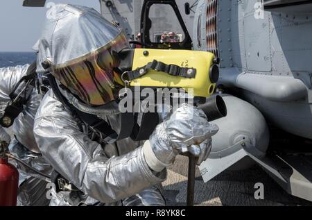 Koreastraße (19. März 2017) Maschinen Handwerker Feuerwehrmann Joihn Suarez, aus Miami, mit einer Wärmebildkamera auf dem Flugdeck der Ticonderoga-Klasse geführte-missile Cruiser USS Lake Champlain (CG57) bei einem Crash und Bergung bohren. Lake Champlain ist in regelmäßigen Western Pacific Bereitstellung mit der Carl Vinson Carrier Strike Group als Teil der US-Pazifikflotte-Initiative die Befehls- und Steuerfunktionen der USA 3 Flotte in der Indo-Asia zu verlängern - Pazifik Region. Navy Flugzeugträger Streik Gruppen haben die Indo-Asia - Pazifik regelmäßig und routinemäßig für m patrouillierten Stockfoto