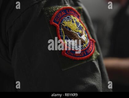 Kapitän Jason Carroll, 15 Airlift Squadron airdrop Fluglehrer trägt die 15. als Patch während eines Fluges nach Norden Auxiliary Airfield in Nord-, Süd Carolina, 15. März 2017 In-flight Training mit aircrew Augen- und Atemschutz System (AERPS) Geräten auszuführen. Der Flug war das erste Mal in mehr als 10 Jahren, in denen Piloten AERPS Ausrüstung trug. AERPS Ausrüstung besteht aus einem Gummi Maske, mehrere Schichten von Stiefel und Handschuhe, Fan Filter System und ein Audio- und Lautsprechersystem. Stockfoto