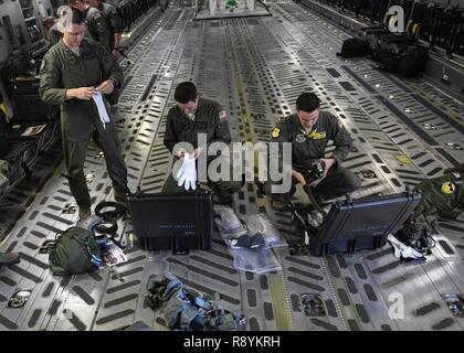 Kapitän Bryce Wehr, Links, 15 Airlift Squadron Pilot, Kapitän Jason Carroll, Mitte, 15. Als airdrop Fluglehrer und 2 Lt Nick Hartsock, 15 Airlift Squadron Pilot, öffnen ihre aircrew Augen- und Atemschutz System (AERPS) Kits vor einem Flug nach Norden Auxiliary Airfield in Nord-, Süd Carolina, 15. März 2017 In-flight Training mit (AERPS) Geräten auszuführen. Der Flug war das erste Mal in mehr als 10 Jahren, in denen Piloten AERPS Ausrüstung trug. AERPS Ausrüstung besteht aus einem Gummi Maske, mehrere Schichten von Stiefel und Handschuhe, Fan Filter System und eine Audio und Lautsprecher Syst Stockfoto