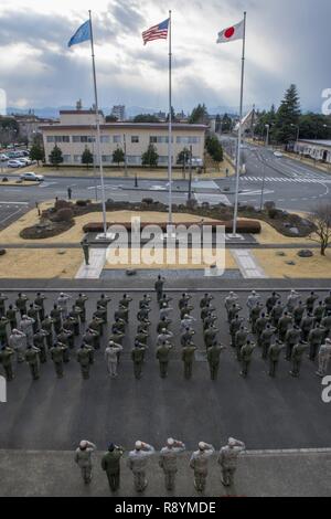 Mitglieder der 374 Gruppe Betrieb begrüssen bei einem Rückzug Zeremonie März 17, 2017, Yokota Air Base, Japan. Die Exerzitien Zeremonie dient als eine Art und Weise Bezug auf die Fahne zu bezahlen und das Ende des offiziellen Pflicht Tag mit dem Abspielen der US-Nationalhymne beim Absenken und Falten die Flagge. Stockfoto