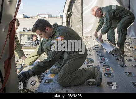 Aircrew Mitglieder aus den 349 Air Mobility Wing, Vorbereitung einer KC-10 Extender Flugzeuge palettierte Ladung von 60 k Tunner, Lader, Jan. 17, 2017 zu erhalten, Travis Air Force Base, Calif. Personal sowohl aus dem 60. Antenne Anschluss Squadron Ramp Services und die Crew loadmasters sicher Laden und Entladen von Flugzeugen kontinuierlich bei Travis, Bereitstellung der Nation globale Reichweite und untermauert seine Rolle als globale Macht. Stockfoto